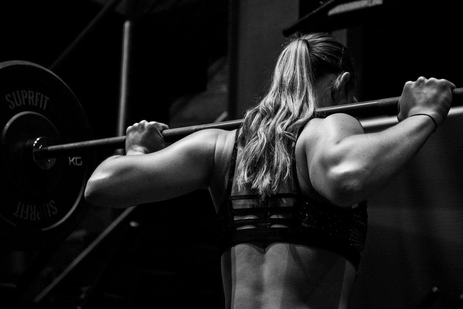 バーベルを担いでトレーニングする女性
